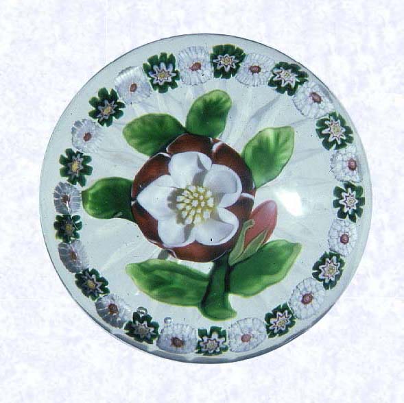 <B>Lampworked Red and White Buttercup<BR>France<BR>Baccarat, circa 1845-55</B><BR>Diameter: 6.5 cm (2 1/2 inches)<BR>702255)<BR><BR>Lampworked red and white buttercup blossom with a deep pink bud; yellow and white center cane; six green leaves and stem; encircled by a ring of alternating green and white millefiori canes; star-cut base: lower sides cut with vertical flutes tapering to the base