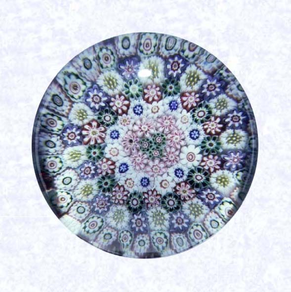<B>Close Concentric Millefiori with Basket Base<BR>France<BR>Clichy, circa 1845-55</B><BR>Diameter: 7 cm (2 3/4 inches)<BR>(702296)<BR><BR>Close concentric millefiori with six concentric rings of multicolored millefiori canes; cluster of three green canes in center; pedestal base with blue and white staves; rounded foot