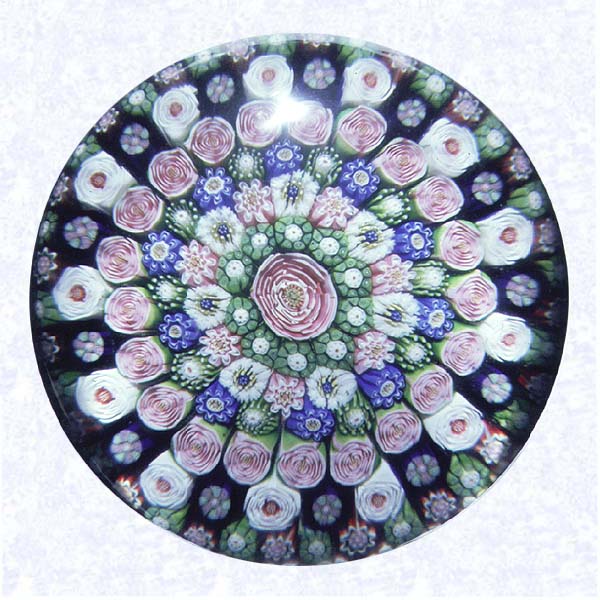 <B>Clichy Rose Close Concentric Millefiori<BR>France<BR>Clichy, gilded base dated 1845</B><BR>Diameter: 7.3 cm (2 7/8 inches)<BR>(702323)<BR><BR>Close concentric millefiori with six rings of millefiori canes in deep purple, green, pink, and white around a pink Clichy rose; fourth ring contains twenty-one pink Clichy roses; fifth ring contains thirteen white Clichy roses; pedestal column of blue and white staves; gilded metal foot (see side view and QTVR) engraved 