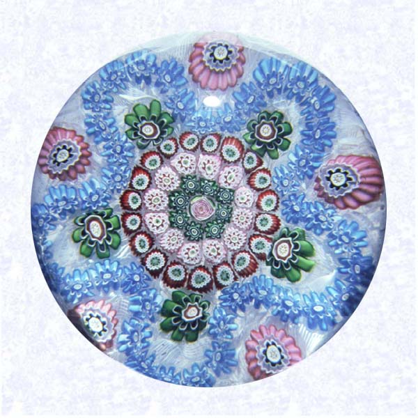 <B>Turquoise Cinquefoil Garland Millefiori<BR>France<BR>Clichy, circa 1845-55</B><BR>Diameter: 8.2 cm (3 1/4 inches)<BR>(702324)<BR><BR>Garland millefiori with a turquoise garland, encircling three concentric circles of red, pink, and green canes, around a pink Clichy rose center; green and pink canes spaced between lobes; on a white filigree ground backed with parallel lengths of white filigree twists