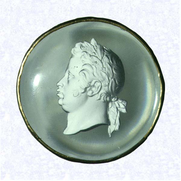 <B>Sulphide Portrait by Feuillet<BR>France<BR>Baccarat, circa 1820</B><BR>Diameter: 5.7 cm (2 1/4 inches)<BR>(702464)<BR><BR>Circular clear glass plaque enclosing a sulphide profile portrait of an unidentified man wearing a laurel wreath; sulphide by French porcelainmaker Feuillet; " FEUILLET,/Rue de la Paix,/No. 20, a Paris" inscribed on backside of sulphide; thin gilded metal band encircles plaque
