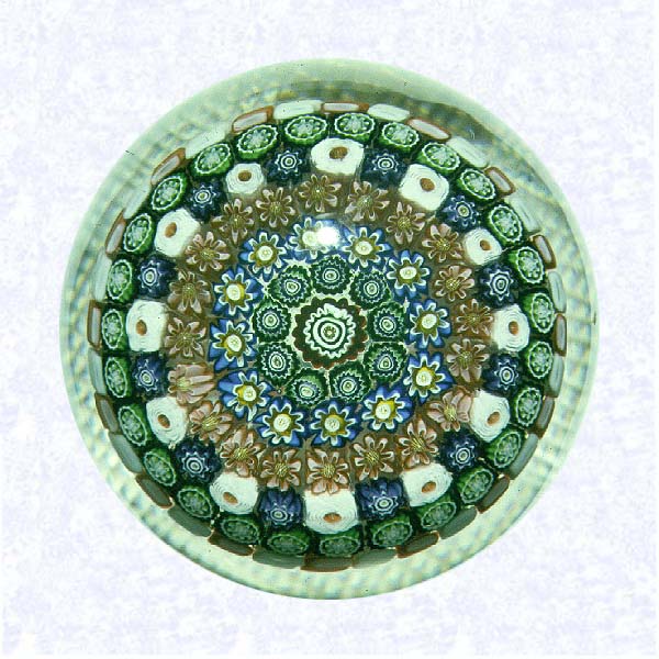 <B>Millefiori Mushroom<BR>France<BR>Clichy, circa 1845-55</B><BR>Diameter: 6.5 cm (2 1/2 inches)<BR>(702483)<BR><BR>Close concentric millefiori mushroom with pink and white staves; twelve white Clichy roses appear in the fourth ring of mushroom; grid-cut base; remains of white overlay along lower sides; dome reground