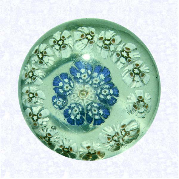 <B>Miniature Millefiori<BR>Possibly Bohemia<BR>factory unknown, mid- to late-nineteenth century</B><BR>Diameter: 4.2 cm (1 5/8 inches)<BR>(702488)<BR><BR>Miniature spaced concentric millefiori weight with an outer ring of white millefiori canes; inner ring of blue canes encircling a white center cane; flat ground base