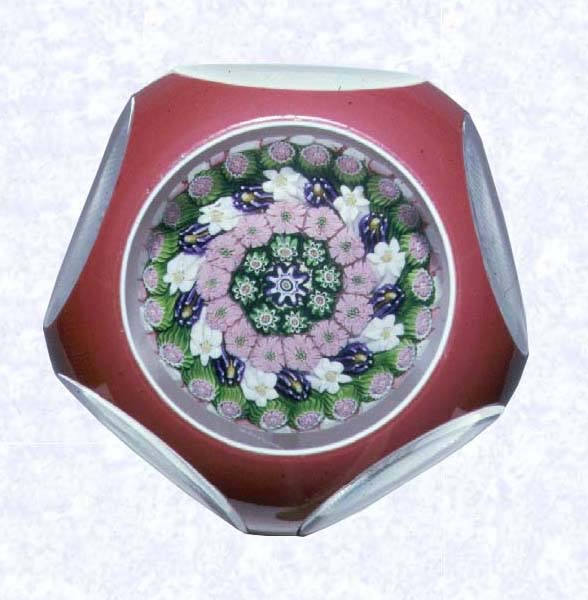 <B>Double Overlay with Millefiori Mushroom<BR>France<BR>Clichy, circa 1845-55</B><BR>Diameter: 7.3 cm (2 7/8 inches)<BR>(702246)<BR><BR>Double overlay (opaque white overlaid with rose), enclosing a close concentric millefiori mushroom with a pink and white stave basket; grid-cut base; sides cut with five circular printies, one on top