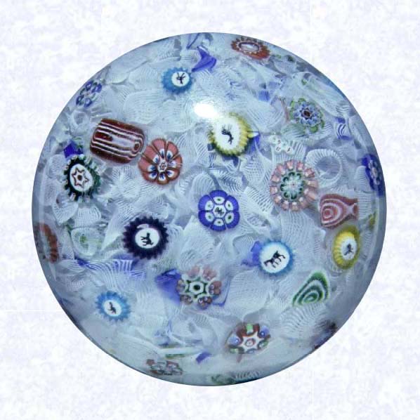 <B>Magnum Spaced Millefiori<BR>France<BR>Baccarat (signed), dated 1848</B><BR>Diameter: 9.5 cm (3 3/4 inches)<BR>(702290)<BR><BR>Magnum weight with spaced millefiori canes, including thirteen silhouette canes and one signed and dated cane inscribed &quotB/1848;" set on a white filigree ground containing blue, green, red, and yellow twisted ribbons; diamond-cut base