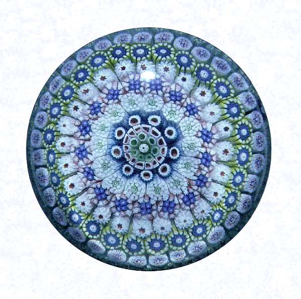 <B>Close Concentric Millefiori with White Lattice Basket<BR>France<BR>Saint Louis (signed), dated 1848</B><BR>Diameter: 8 cm (3 1/8 inches)<BR>(702295)<BR><BR>Close concentric millefiori with nine concentric rings of multicolored millefiori canes, including one black signed and dated cane inscribed &quotSL/1848" in the outermost ring; solid basket pedestal base formed of white lattice with a white spiral torsade at the rim and foot (see side view)