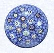 Spaced Millefiori on Carpet GroundFranceBaccarat (signed), dated 1848Diameter: 7.3 cm (2 7/8 inches)(702299)Carpet ground of blue and white star and rod canes; inset with spaced millefiori canes, including five silhouettes and one signed and dated cane inscribed &quotB/1848"