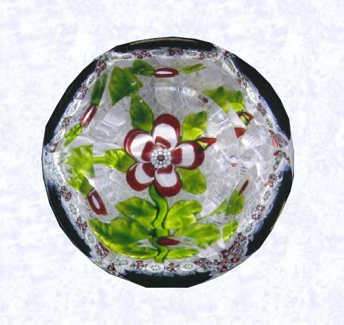 <B>Lampworked Pink and White Primrose<BR>France<BR>Baccarat, circa 1845-55</B><BR>Diameter: 6.5 cm (2 1/2 inches)<BR>(702305)<BR><BR>Deep pink and white banded primrose blossom witih a red bud; white center cane; six leaves and stem; encircled by a ring of alternating white and red millefiori canes; on a white filigree ground; sides cut with six circular printies, one on top (formerly in the collection of King Farouk of Egypt)