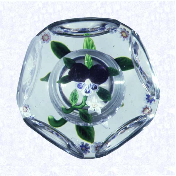 <B>Lampworked Pansy Bouquet<BR>France<BR>Baccarat, circa 1845-55</B><BR>Diameter: 7.6 cm (3 inches)<BR>(702318)<BR><BR>Lampworked flat bouquet of one purple pansy with blue and white lower petals, and one small white clematis blossom; seven green leaves and stem; encircled by a ring of alternating blue and white, and red and white millefiori canes; sides cut with five circular printies, one on top