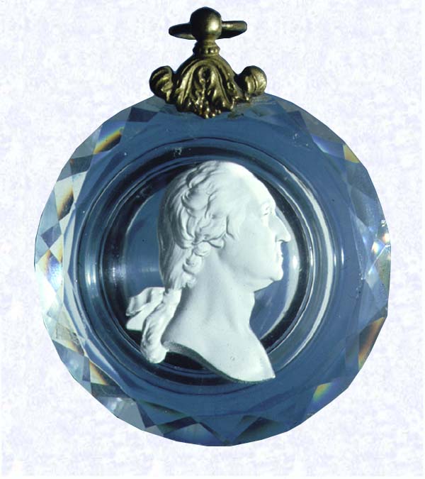 <B>George Washington Sulphide Portrait<BR>France<BR>Baccarat, circa 1800</B><BR>Diameter: 8 cm (3 1/8 inches) Maximum Length: 11.1 cm (4 3/8 inches)<BR>(702330)<BR><BR>Circular clear glass plaque with faceted edges, enclosing a sulphide profile portrait of George Washington; 
