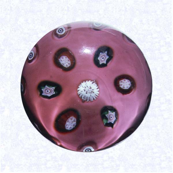 <B>Spaced Millefiori Set in Rose Pink<BR>France<BR>Clichy (?), circa 1845-55</B><BR>Diameter: 6.5 cm (2 1/2 inches)<BR>(702348)<BR><BR>Spaced millefiori canes in green, red, white, and pink; set in a rose pink over opaque white ground; canes set deep into concavities in ground