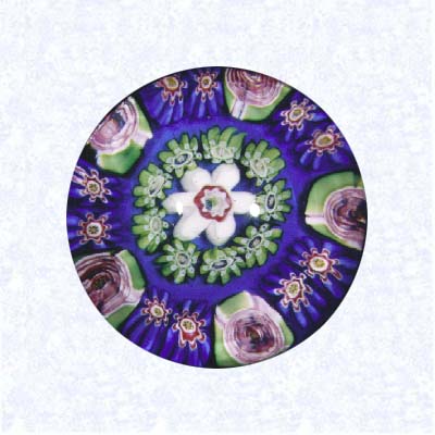 <B>Miniature Pattern Millefiori on Blue<BR>France<BR>Clichy, circa 1845-55</B><BR>Diameter: 4.2 cm (1 5/8 inches)<BR>(702369)<BR><BR>Miniature pattern millefiori with concentric rings of millefiori canes in blue, green, and white, including five pink Clichy roses in the outermost ring; center white flower-shaped cane