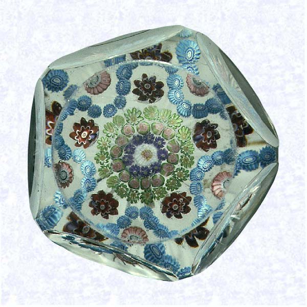 <B>Cinquefoil Garland Millefiori<BR>France<BR>Clichy, circa 1845-55</B><BR>Diameter: 7.6 cm 3 inches)<BR>(702380)<BR><BR>Garland millefiori with a light blue cinquefoil garland, encircling three concentric rings of green and purple canes; fourteen pink Clichy roses form a second ring around a white center cane; pink and red canes spaced between lobes; star-cut base; sides cut with five large circular printies; circular facet cut on top