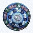 Spaced Concentric Millefiori on BlueFranceClichy, circa 1845-55Diameter: 7.6 cm (3 inches)(702382)Spaced concentric millefiori with three spaced rings; outer ring with alternating pink and green canes, middle ring with alternating dark blue and white canes, inner ring of white canes; around a pink and white center cane; on a light blue opaque ground