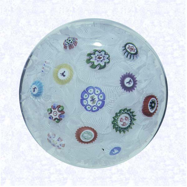 <B>Spaced Millefiori on Filigree<BR>France <BR>Baccarat, dated 1849</B><BR>Diameter: 6 cm (2 3/8 inches)<BR>(702388)<BR><BR>Spaced millefiori canes, including six silhouette canes and one dated cane inscribed &quot1849" (&quot1849" reversed); on a white filigree ground