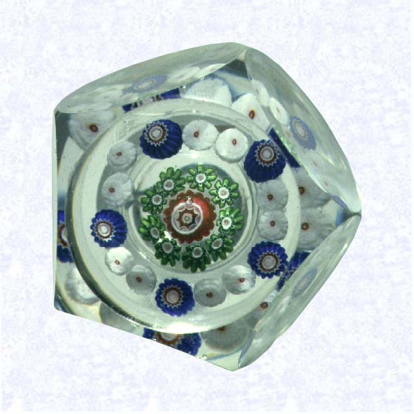 <B>Pentagonal Miniature Millefiori<BR>France<BR>Clichy, circa 1845-55</B><BR>Diameter: 4.5 cm (1 3/4 inches)<BR>(702393)<BR><BR>Miniature pattern millefiori weight with blue, green, and red millefiori canes, including ten white Clichy roses in the outermost ring; sides cut with five circular printies, one on top