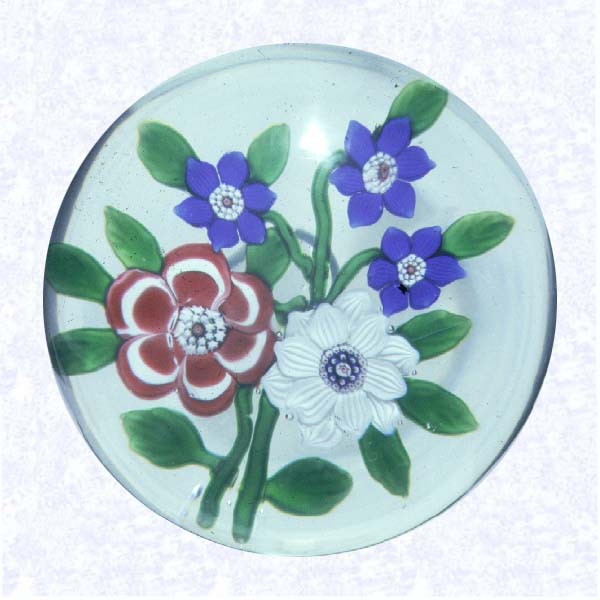 <B>Lampworked Red, White, and Blue Bouquet<BR>France<BR>Baccarat, circa 1845-55</B><BR>Diameter: 7.6 cm (3 inches)<BR>(702394)<BR><BR>Flat Lampworked bouquet of one red and white primrose, one white clematis, and three deep blue flowers; green leaves and stems