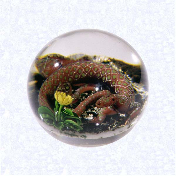 <B>Lampworked Salamander<BR>France<BR>Pantin (attributed), late-nineteenth century</B><BR>Diameter: 10.5 cm (4 1/8 inches)<BR>(702399)<BR><BR>Lampworked three-dimensional, brownish pink salamander with cream scales and green dots; on a sandy ground heavily mottled with dark green algae; yellow upright flower with green foliage