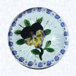 Pansy with Millefiori RingFranceBaccarat, circa 1845-55Diameter: 8.9 cm (3 1/2 inches)(702400)Purple lampworked pansy with three yellow and purple lower petals and a purple bud; seven green leaves and stem; encircled by a ring of alternating blue and white millefiori canes; star-cut base