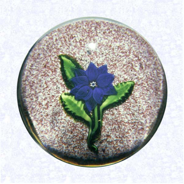 <B>Lampworked Clematis on Jasper Ground<BR>France<BR>Saint Louis, circa 1845-55</B><BR>Diameter: 6.5 cm (2 1/2 inches)<BR>(702406)<BR><BR>Deep blue lampworked clematis blossom with a red, white, and blue center cane; three green leaves and stems; on a red and white jasper ground