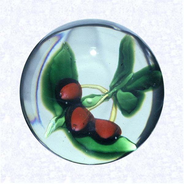 <B>Lampworked Cherries<BR>France<BR>United States<BR>New England Glass Company,<BR>Cambridge, Massachusetts, circa 1852-1880</B><BR>Diameter: 6.5 cm (2 1/2 inches)<BR>(702418)<BR><BR>Lampworked fruit weight with three red cherries attached to a yellow-green branch by yellow stems; five green leaves