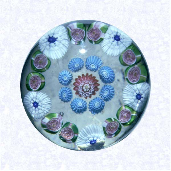 <B>Miniature Pattern Millefiori with Clichy Roses<BR>France<BR>Clichy, circa 1845-55</B><BR>Diameter: 4.5 cm (1 3/4 inches)<BR>(702357)<BR><BR>Miniature pattern millefiori weight with concentric rings of millefiori canes in white, blue, and red, including ten pink Clichy roses in the outermost ring