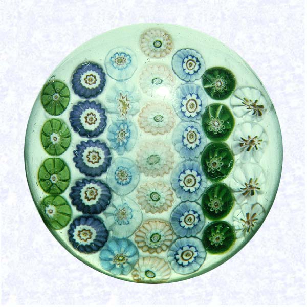 <B>Parallel Rows Millefiori<BR>France<BR>Clichy, circa 1845-55</B><BR>Diameter: 7.6 cm (3 inches)<BR>(702481)<BR><BR>Pattern millefiori with seven parallel rows of millefiori canes in white, green, blue, pink, and purple; on an opaque white ground